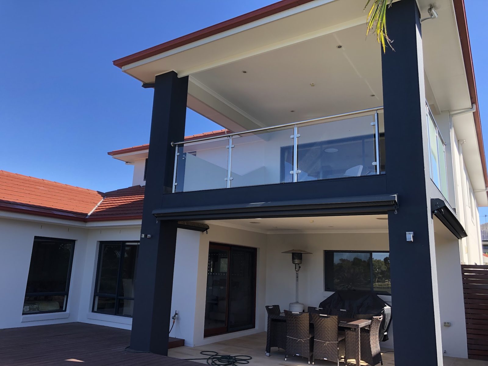 Rendered home painted white with charcoal posts and balcony frame